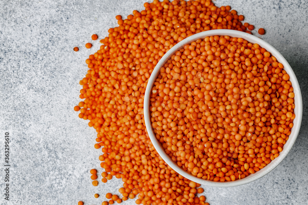 White ceramic bowl of red lentils on wooden table White ceramic bowl of red lentils on wooden table