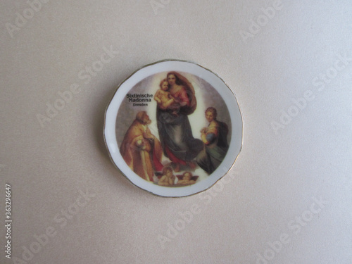 Colorful German souvenir fridge magnet on light silver paper background. Magnet with symbol of Dresden Art Gallery - famous Raphael painting - Sistine Madonna.