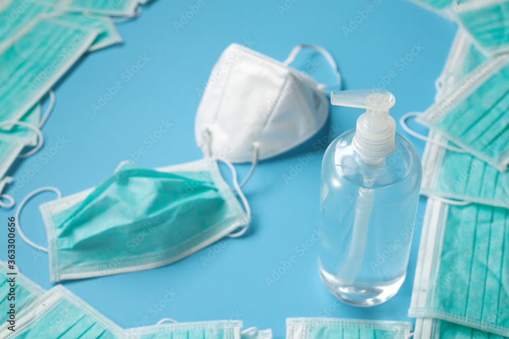 KN95 Medical face mask with alcohol sanitizer gel hand wash bottle on blue background covid-19 Coronavirus prevention concept KN95 Medical face mask with alcohol sanitizer gel hand wash bottle on blue background covid-19 Coronavirus prevention concept