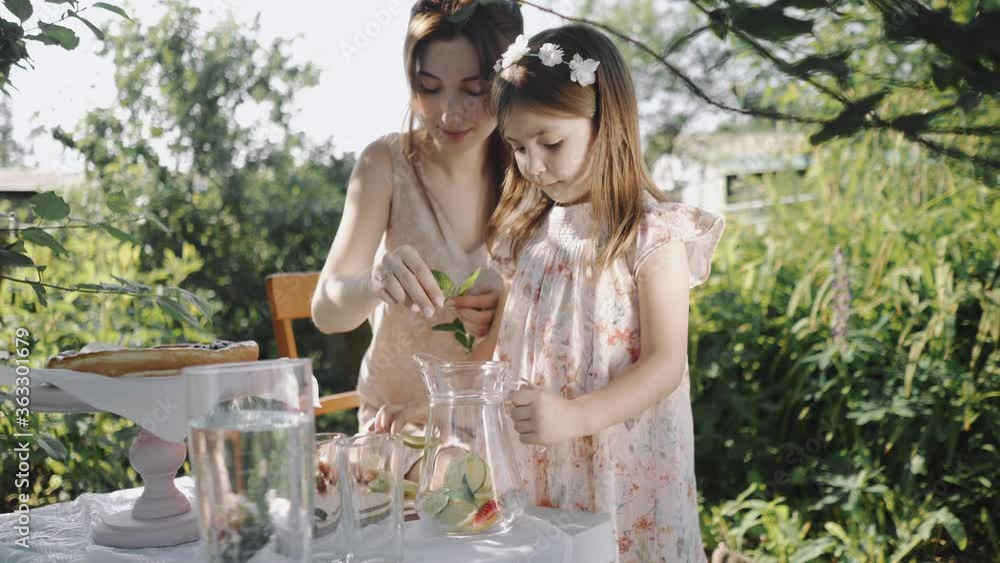 Mother and daughter cut lemon and make homemade lemonade Mother and daughter cut lemon and make homemade lemonade