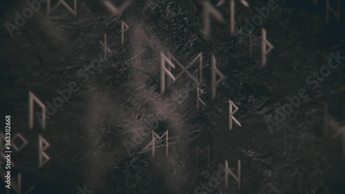 Dark grunge runic motion background with gently moving metallic runes and black rock texture. photo