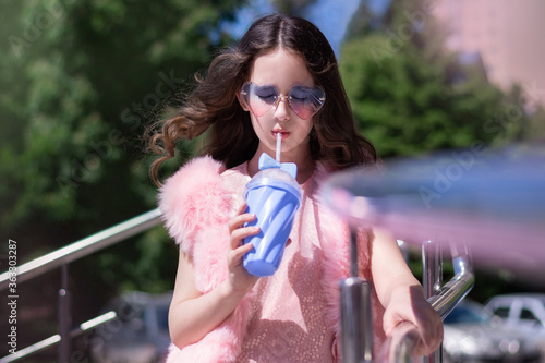 Девушка  в очках пьёт коктейль