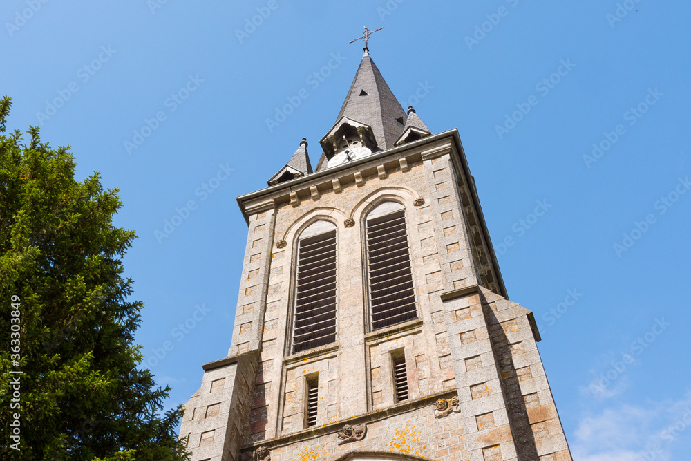 Beautiful close up of Notre-Dame-de-l'Assomption church tower (La Lande Patry, Normandy, France). Sunny day in the north of France. Stone christian church.