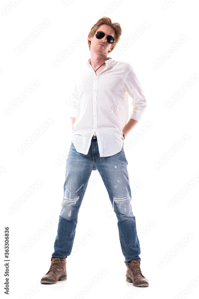 Ginger handsome slim young stylish man with sunglasses posing with hands behind back. Full body length isolated on white background. Ginger handsome slim young stylish man with sunglasses posing with hands behind back. Full body length isolated on white background.