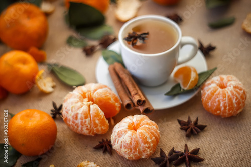 Beautiful still life. Close-up.  cup of coffee  tangerines and cinnamon Peeled Tangerine orange and Tangerine orange slices on a Dark Background. Citrus background  Top view.