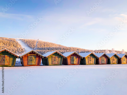  Levi, Kittila, Lapland, Finland: Christmas market with christmas gifts covered with snow at the ski paths. Colorful wooden houses.  photo