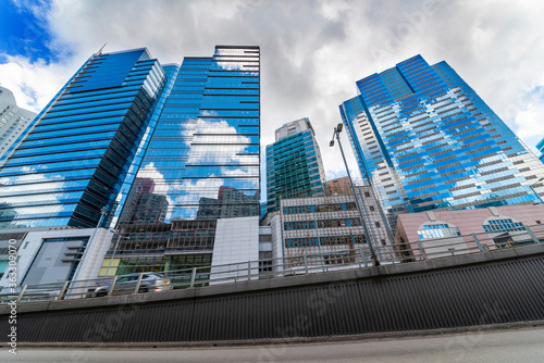 Tall buildings on the sky light rail and ground bus stops.