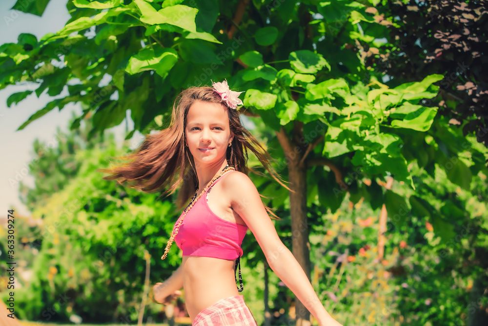 Model looking Girl in a pink topic posing on the background of green grass and forest. Model looking Girl in a pink topic posing on the background of green grass and forest.