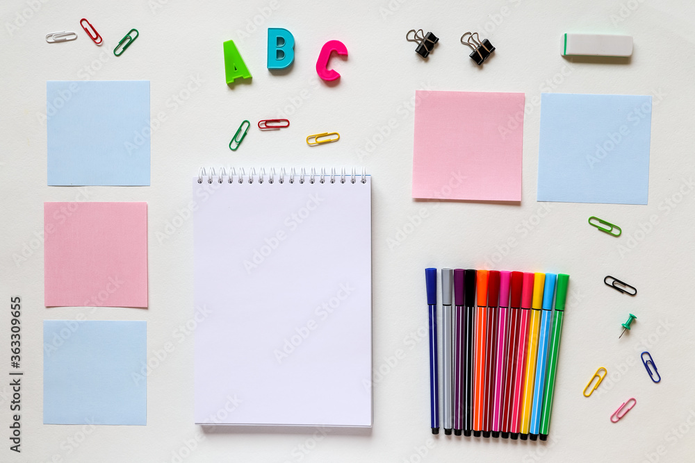 concept of education. on a white background are spread out notes and colored markers concept of education. on a white background are spread out notes and colored markers