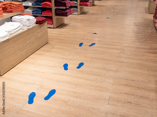 Footprints painted in front of a store to respect social distance by customers (Coronavirus epidemic).