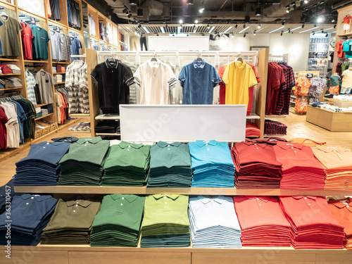 Foto Colorful polo t shirt stack on shelf in large department store shop
