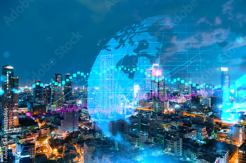 FOREX graph hologram, aerial night panoramic cityscape of Bangkok, the developed location for stock market researchers in Asia. The concept of fundamental analysis. Double exposure. photo