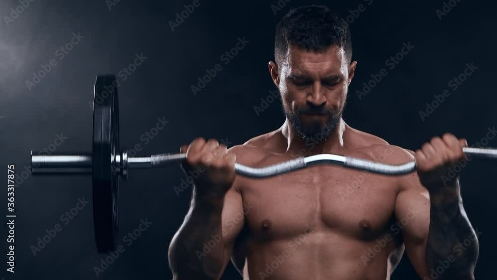 Fit and sporty bodybuilder over black background. Bodybuilder training using barbell. Sport and fitness. Fit and sporty bodybuilder over black background. Bodybuilder training using barbell. Sport and fitness.