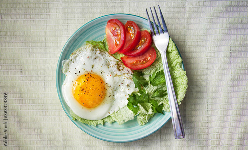 fried egg with tomatoes and parsley on wooden background