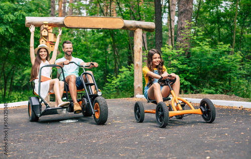 Modern happy young tourist family on vacation riding on bikes and have fun together.