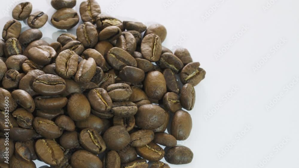 Dark Coffee beans rotating. Close up of roasted coffee beans on white background. Shallow depth of field Dark Coffee beans rotating. Close up of roasted coffee beans on white background. Shallow depth of field