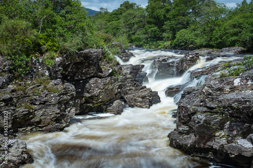 Long exposure shot of the waterfalls in Glen Orchy near Bridge of Orchy in the Argyll region of the highlands of Scotland during summer whilst the river is flowing fast from rainfall