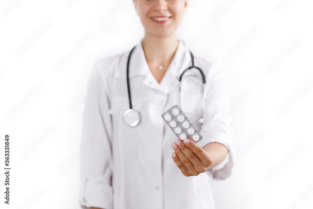 Close-up of male doctor's hand holding pills for his patient. Young Caucasian men medic wearing professional uniform and stethoscope. Close-up of male doctor's hand holding pills for his patient. Young Caucasian men medic wearing professional uniform and stethoscope.