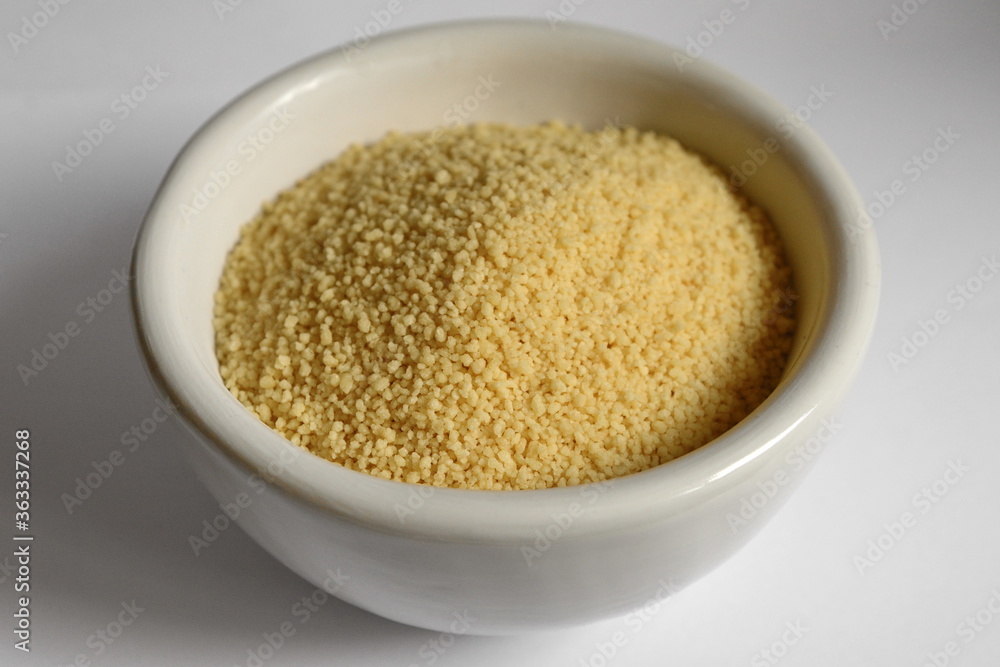 Dry couscous in white ceramic bowl isolated on white. Dry couscous in white ceramic bowl isolated on white.