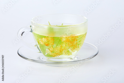 Transparent glass cup of tea with linden isolated on white