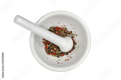 White mortar and pestle with pepper and spices mix isolated on white background.