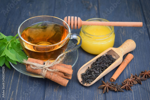 Black tea with star anise and cinnamon and honey on a dark background