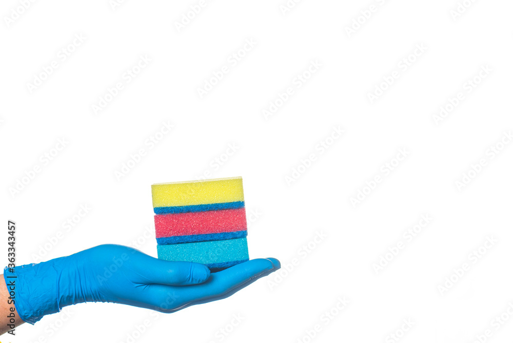 a hand in a blue glove holds multi-colored sponges and a yellow rag for cleaning rooms. on a white background. a hand in a blue glove holds multi-colored sponges and a yellow rag for cleaning rooms. on a white background.