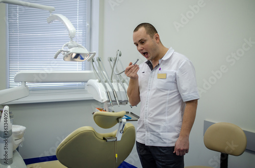 A dentist in his office is preparing to receive a patient.