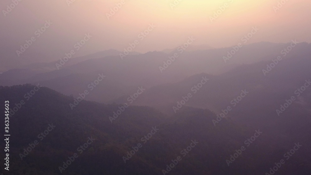 Beautiful sunrise over wild forest mountains in morning in Laos . Aerial Video flying over mountains.