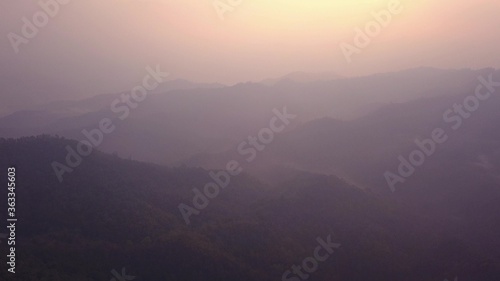 Beautiful sunrise over wild forest mountains in morning in Laos . Aerial Video flying over mountains. © flying creature