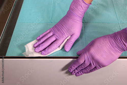 Disinfection of surfaces in the dental office. Close-up of a gloved hand. Copy of the space. Unrecognizable photo. Top view.
