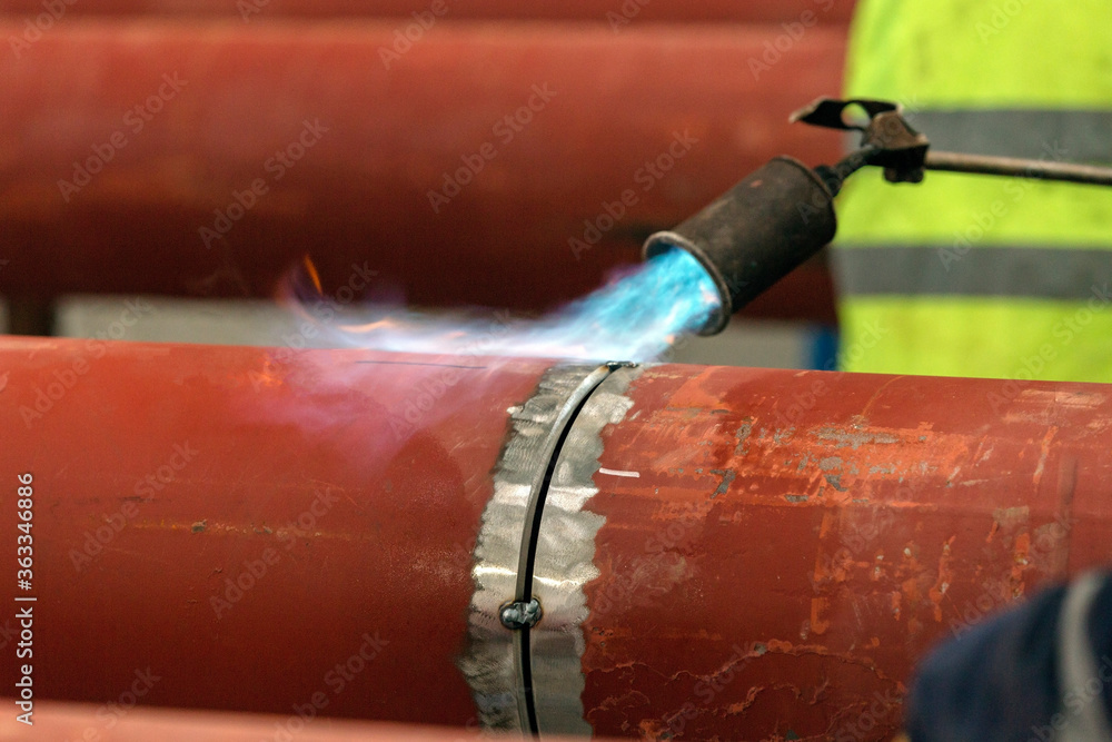 The welder is preheating to pipeline before welding. The phenomenon of