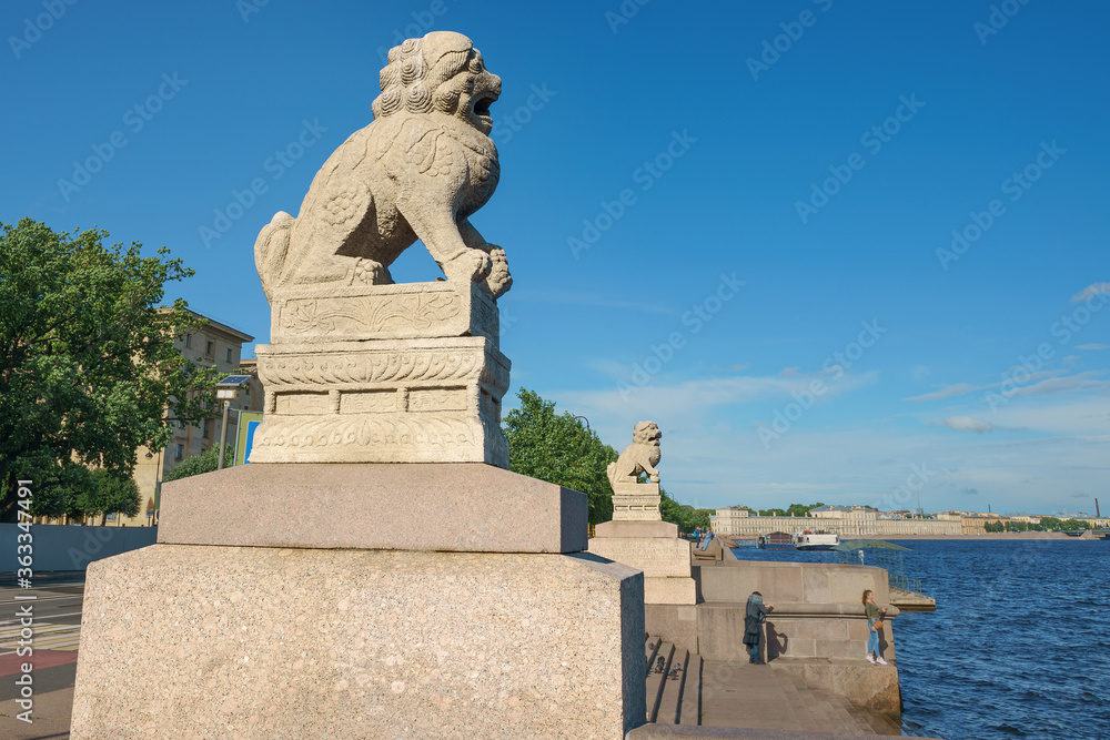 sculpture of a lion on the embankment of the Neva River. Unique urban landscape of St. Petersburg