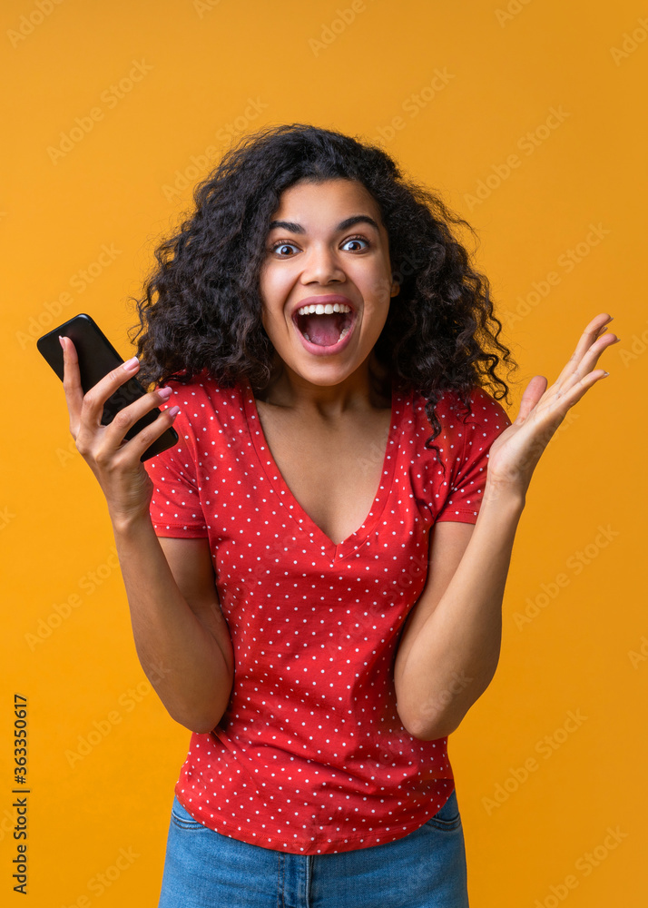 Vertical shot of amazed girl with mobile phone in hands celebrating victory in online casino, hitting jackpot in lotttery, making bets online at bookmaker's website Vertical shot of amazed girl with mobile phone in hands celebrating victory in online casino, hitting jackpot in lotttery, making bets online at bookmaker's website
