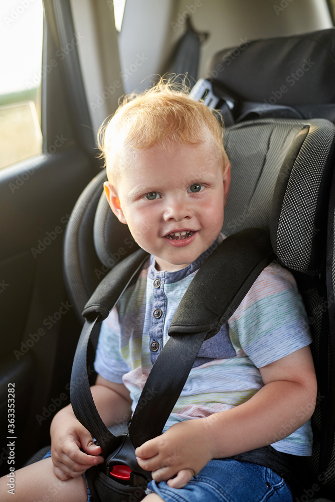 Happy little boy sits in a car seat. Happy little boy sits in a car seat.