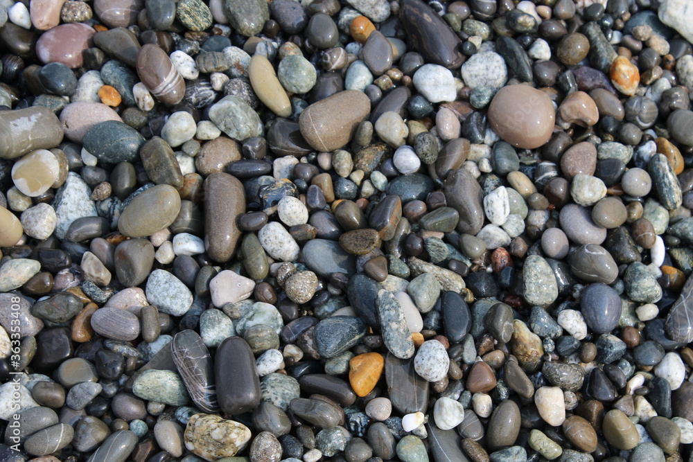 Grey black white brown pebbles stones on the beach background Grey black white brown pebbles stones on the beach background