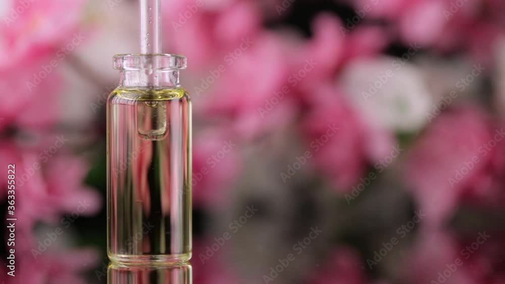 Blend of essential oils closeup. Making some aroma liquids, perfume. Drops falling from pippet to little glass bottle. Slowmotion. Liquid ingredients, body care production, cosmetology. Blend of essential oils closeup. Making some aroma liquids, perfume. Drops falling from pippet to little glass bottle. Slowmotion. Liquid ingredients, body care production, cosmetology.
