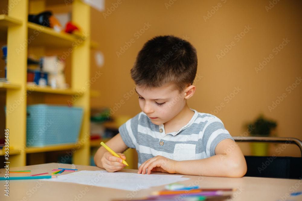 A school-age boy does homework at home. Training at school A school-age boy does homework at home. Training at school