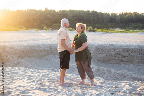 Active seniors kissing in summer nature, senior couple relax in summer time. Healthcare lifestyle elderly retirement love couple together valentines day concept