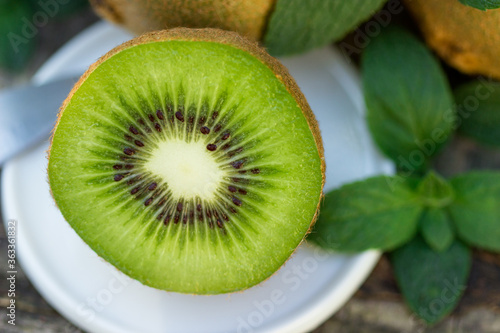 Juicy fruits of kiwi and mint on a wooden background.