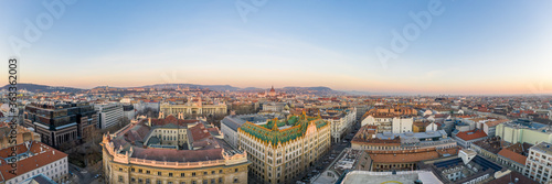 Panoramic Aerial drone shot of art nouveau rooftop postal bank in Budapest dawn with Parliament view