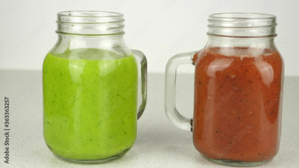 Tracking shot of two colorful fruit smoothies, isolated against a simple white backdrop Tracking shot of two colorful fruit smoothies, isolated against a simple white backdrop