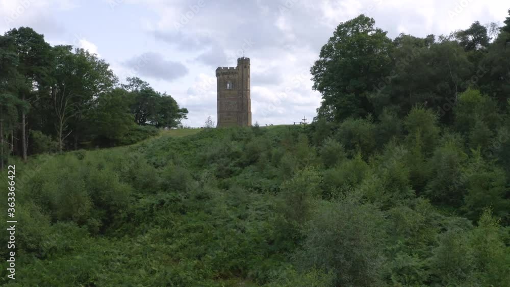Aerial drone shot flying towards and Leith Hill Tower and over cyclists cycling juts getting to the top of the hill with British countryside landscape beyond Aerial drone shot flying towards and Leith Hill Tower and over cyclists cycling juts getting to the top of the hill with British countryside landscape beyond