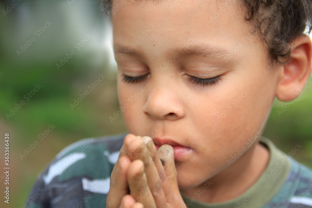 boy praying to God with hands together and closed eyes stock photo boy praying to God with hands together and closed eyes stock photo