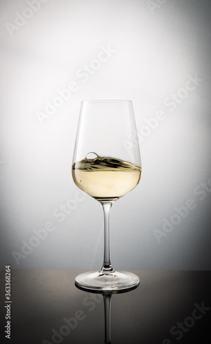 Swirled Glass Filled with White Wine Forming Waives and Bubbles
