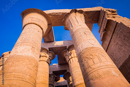 Huge decorated columns with bright blue sky background in Kom Ombo temple. photo