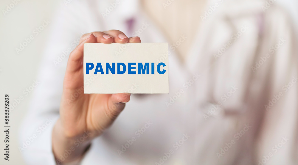 Doctor holding card with the text PANDEMIC Doctor holding card with the text PANDEMIC