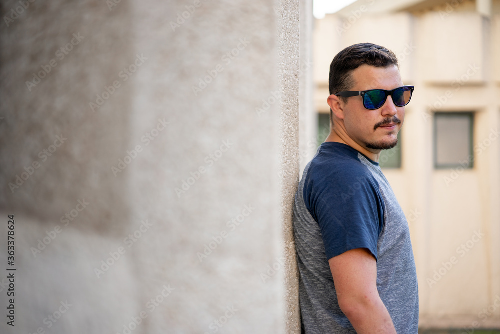 Obraz premium Chico con gafas de sol posa cerca de una ventana