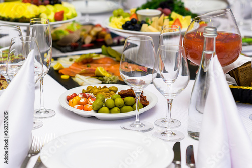 vegetables and fruits and cold snacks on a served table with glass glasses at a restaurant reception