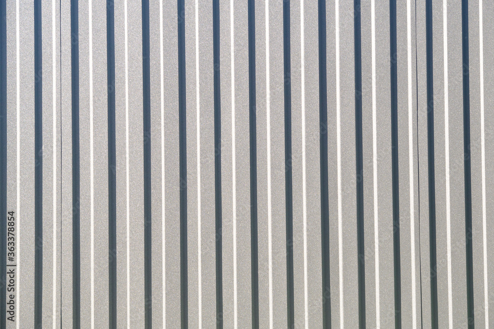 Gray corrugated metal fence on a sunny day..Corrugated surface seamless pattern. Gray corrugated metal fence on a sunny day..Corrugated surface seamless pattern.